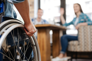rounded-image une personne en fauteuil roulant rejoignant deux autres personnes dans un restaurant